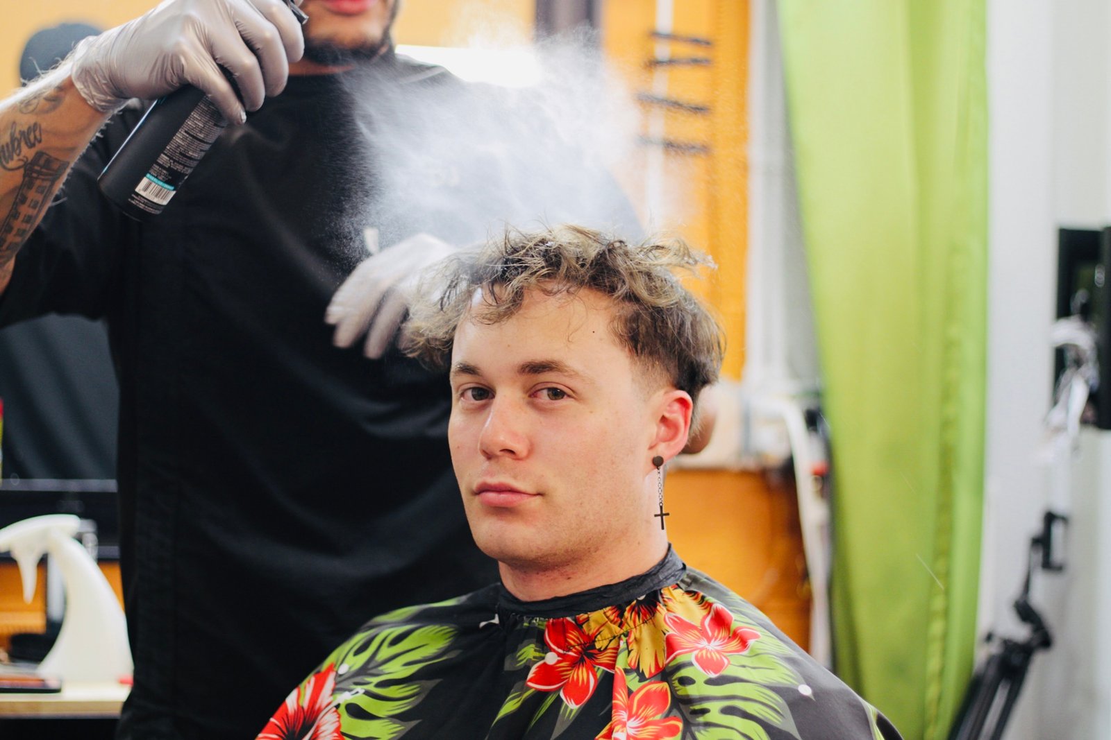 A barber applying product to a client's hair